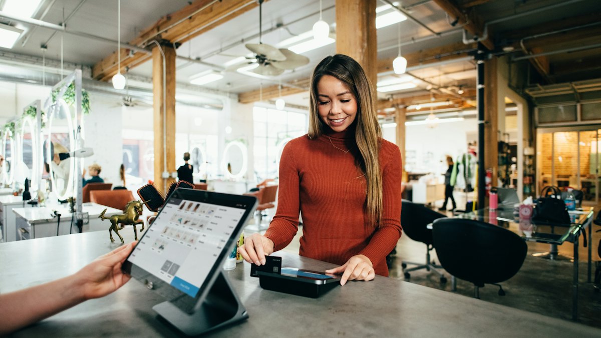 A woman taking a payment on a tablet