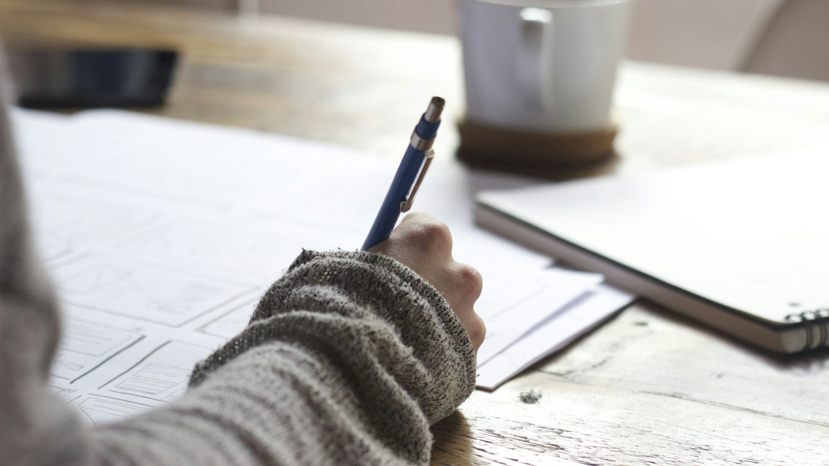 A person writing on paper records