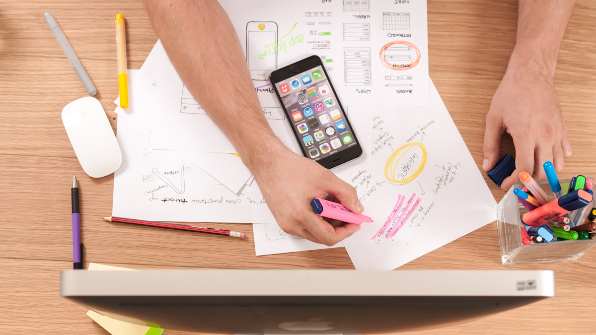 Hands working over papers and a phone